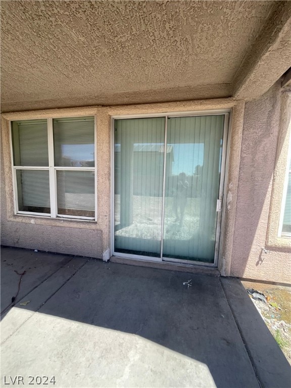 view of exterior entry featuring a patio