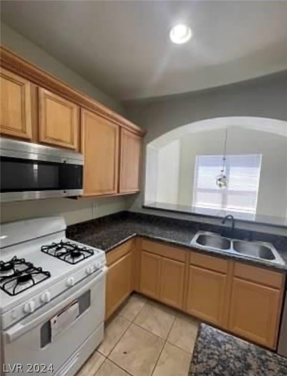 kitchen featuring sink, light tile patterned flooring, and gas range gas stove