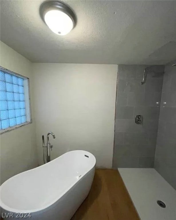 bathroom with tiled shower and a textured ceiling