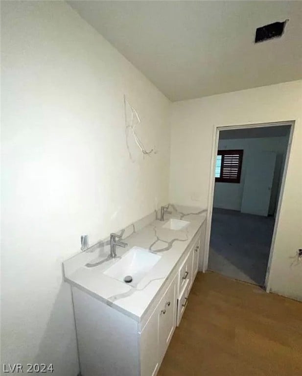 bathroom with hardwood / wood-style floors and double sink vanity