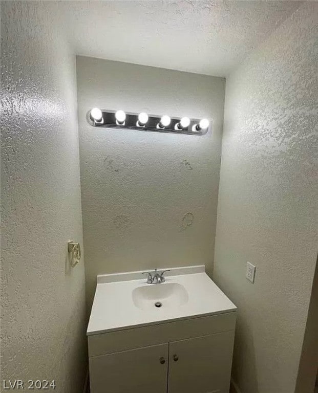 bathroom featuring a textured ceiling and vanity