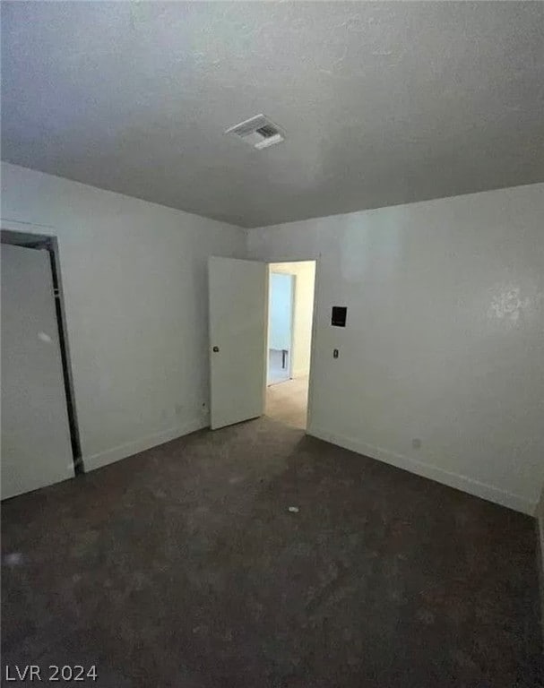 carpeted spare room featuring a textured ceiling