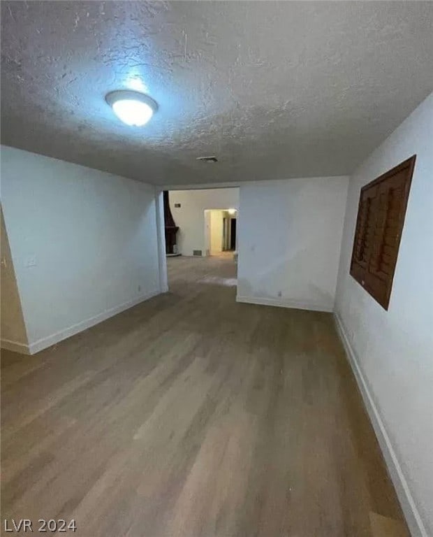 basement with light hardwood / wood-style floors and a textured ceiling