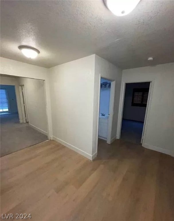 interior space with a textured ceiling and wood-type flooring