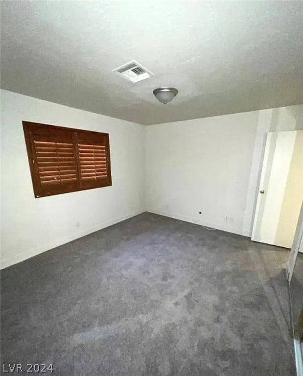 carpeted spare room featuring a textured ceiling