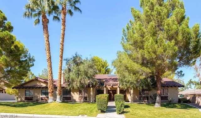 mediterranean / spanish house featuring a front lawn