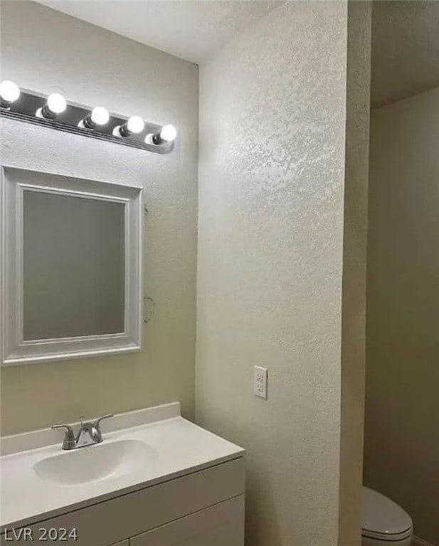 bathroom featuring toilet and vanity