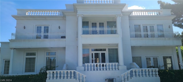 view of front of property with a balcony and french doors