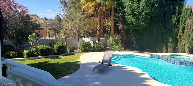 view of pool with a lawn, a patio area, and an in ground hot tub