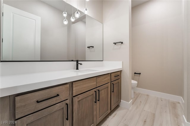 bathroom featuring hardwood / wood-style floors, vanity, and toilet