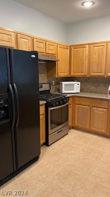 kitchen featuring black refrigerator with ice dispenser, backsplash, light tile floors, and gas range