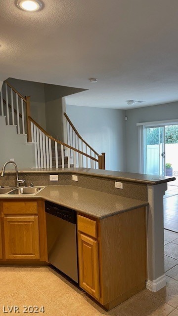 kitchen with light tile flooring, stainless steel dishwasher, and sink