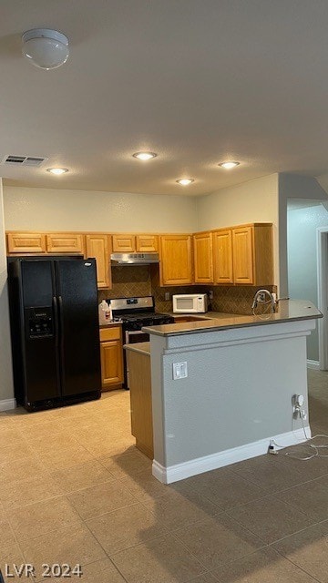 kitchen with backsplash, stainless steel gas range, black fridge with ice dispenser, and light tile floors