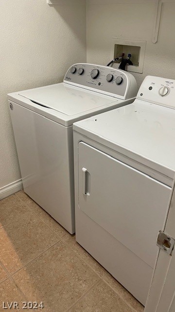 laundry area featuring washer hookup, light tile floors, and washer and dryer