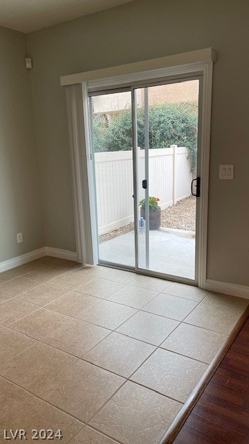 doorway to outside featuring light tile floors and a healthy amount of sunlight