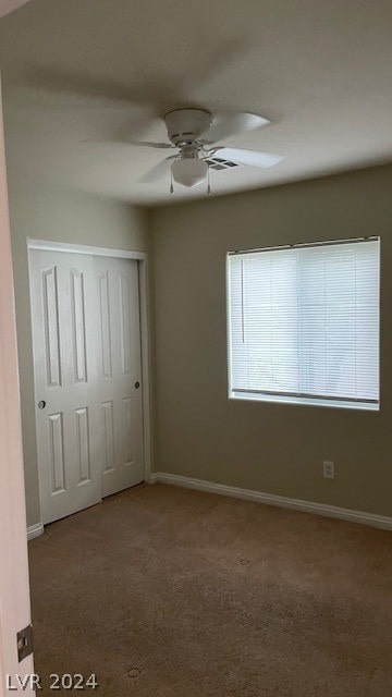 unfurnished bedroom featuring a closet, dark carpet, and ceiling fan