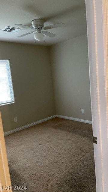 carpeted spare room with ceiling fan