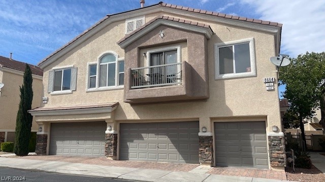 view of property with a balcony and a garage