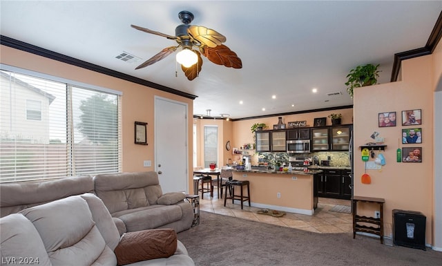 carpeted living room with crown molding and ceiling fan