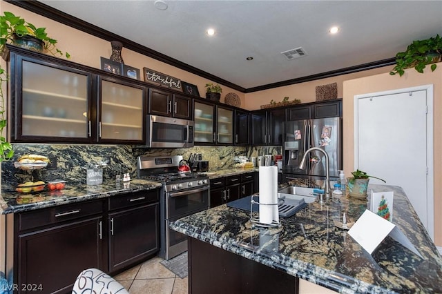 kitchen with crown molding, backsplash, appliances with stainless steel finishes, visible vents, and dark stone counters