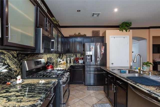 kitchen featuring visible vents, appliances with stainless steel finishes, ornamental molding, a sink, and dark stone countertops