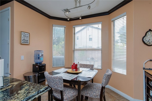 tiled dining room with track lighting and crown molding