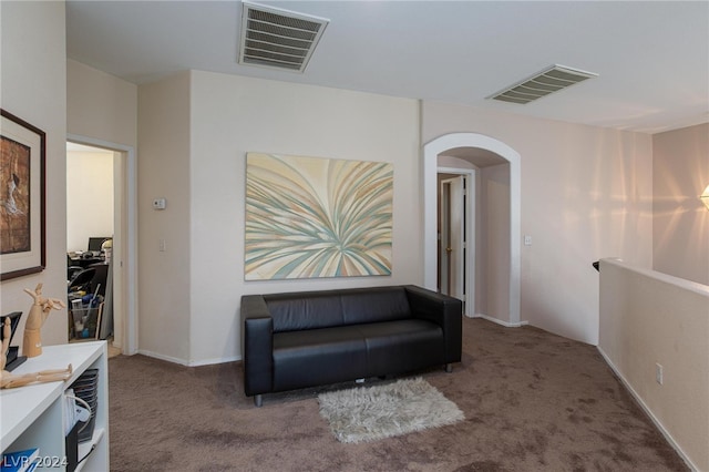 sitting room featuring arched walkways, carpet flooring, and visible vents