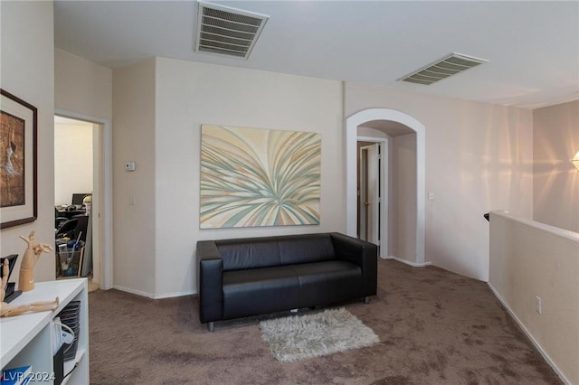 sitting room with visible vents, arched walkways, and carpet