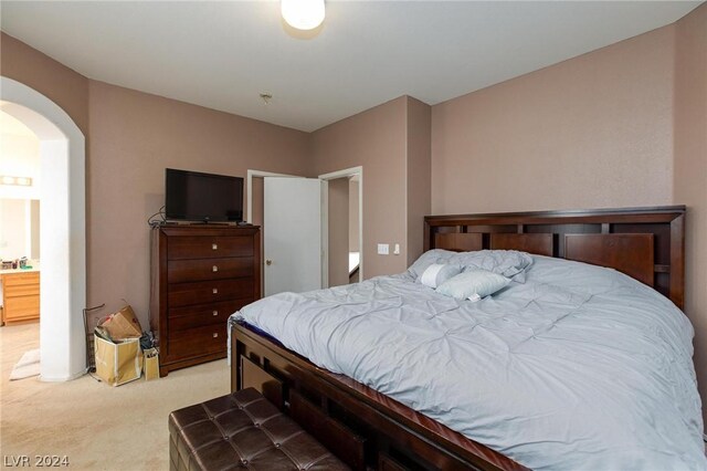 bedroom featuring light carpet and arched walkways