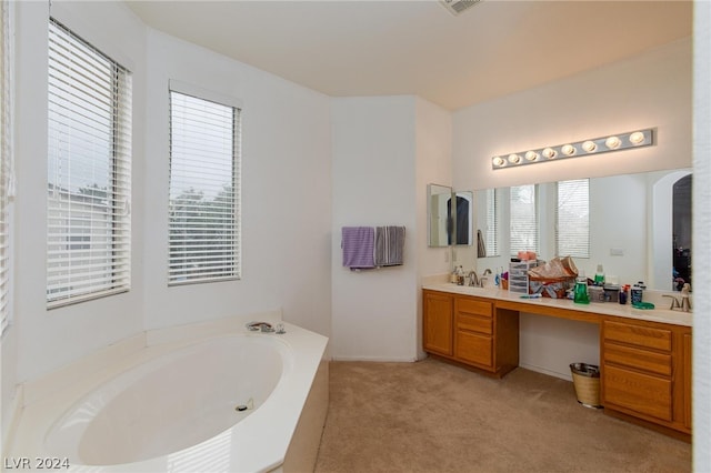 bathroom featuring a bath to relax in and vanity with extensive cabinet space