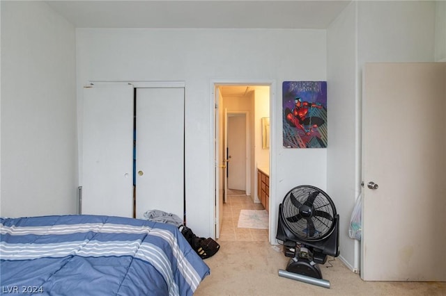bedroom featuring light carpet, connected bathroom, and a closet