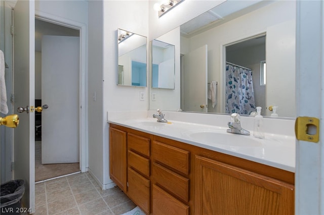 bathroom with tile flooring, dual sinks, and vanity with extensive cabinet space