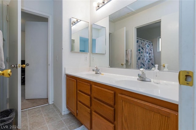 full bathroom featuring double vanity, a sink, and tile patterned flooring