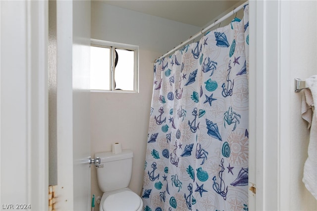 full bath featuring a shower with shower curtain and toilet