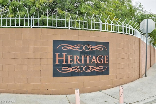 community / neighborhood sign featuring fence