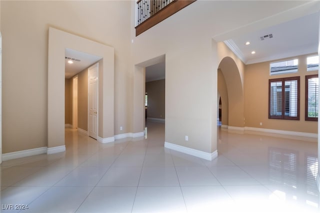 tiled empty room featuring ornamental molding