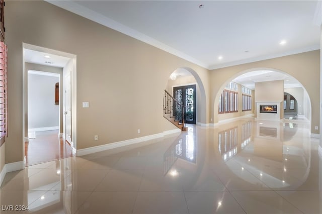 tiled empty room featuring crown molding