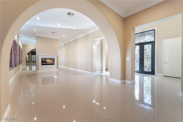 entryway with french doors, light tile patterned floors, and crown molding