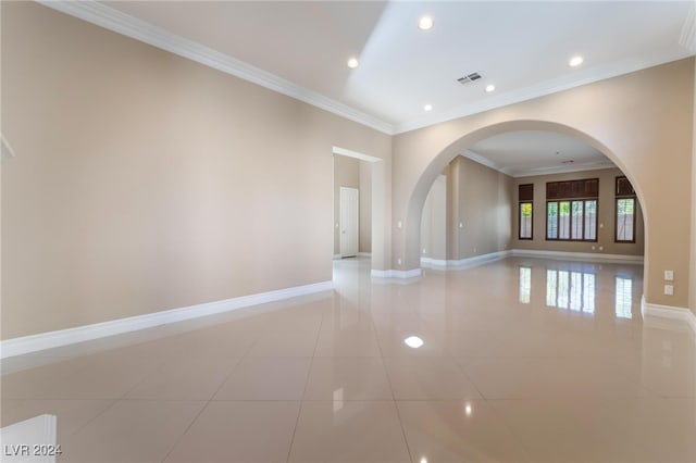 tiled spare room featuring crown molding