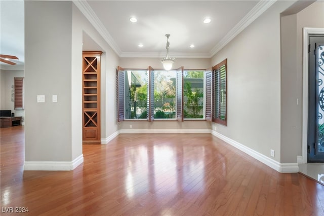 unfurnished dining area with ceiling fan, wood-type flooring, and ornamental molding