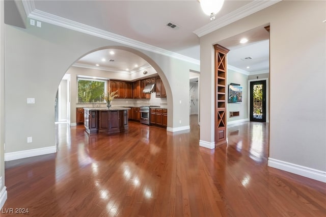 kitchen featuring a kitchen island, tasteful backsplash, dark hardwood / wood-style floors, stainless steel stove, and ornamental molding