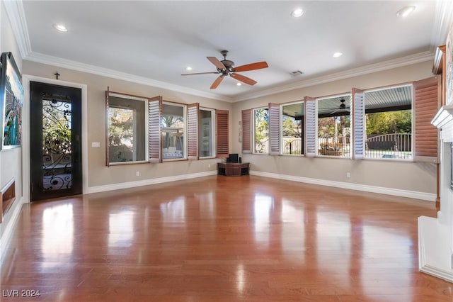 unfurnished living room featuring hardwood / wood-style floors, ceiling fan, and crown molding