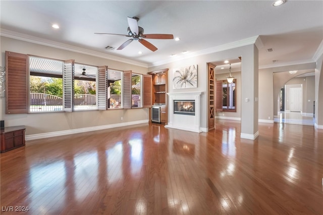 unfurnished living room featuring hardwood / wood-style floors, ceiling fan, and ornamental molding