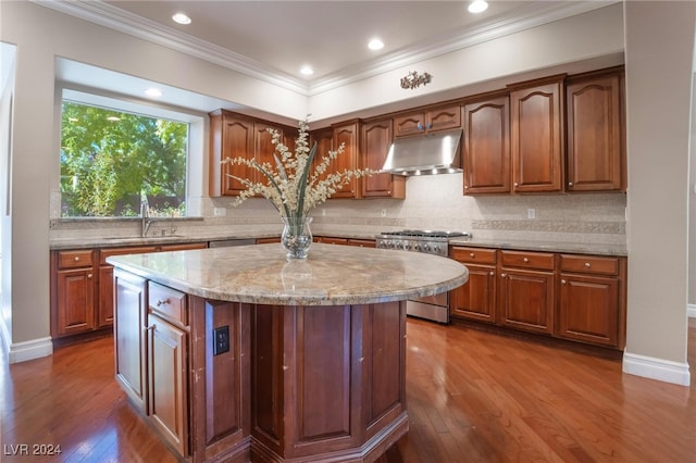 kitchen featuring hardwood / wood-style flooring, a kitchen island, appliances with stainless steel finishes, and tasteful backsplash