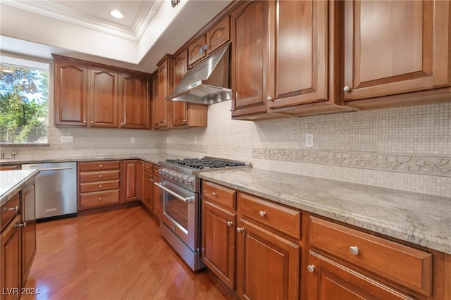 kitchen featuring light stone countertops, appliances with stainless steel finishes, hardwood / wood-style flooring, and ornamental molding