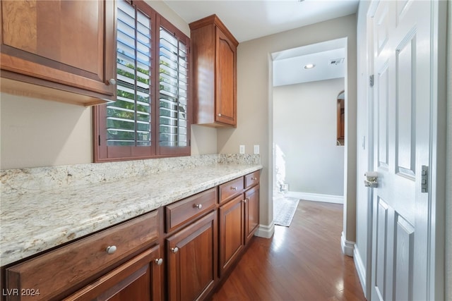 kitchen with light stone countertops and hardwood / wood-style floors