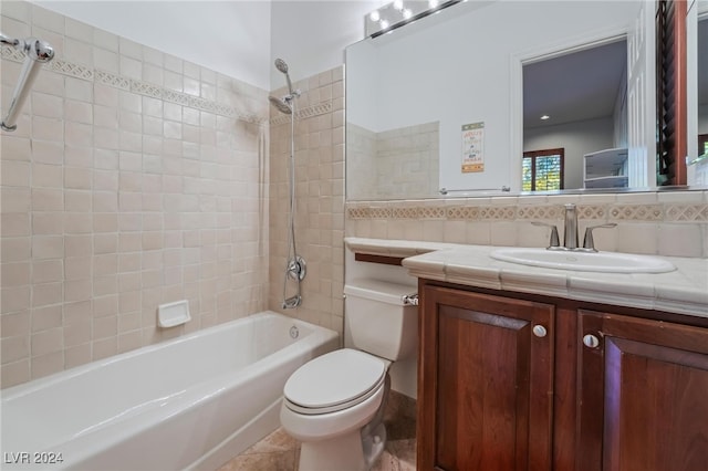 full bathroom featuring tiled shower / bath combo, tile patterned flooring, toilet, vanity, and tile walls