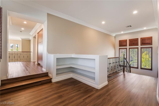 hallway featuring a healthy amount of sunlight, crown molding, and wood-type flooring