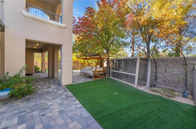 view of yard featuring a sunroom, a balcony, and a patio