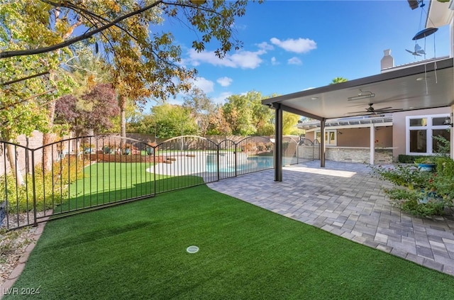 view of yard with ceiling fan, a patio area, and a fenced in pool